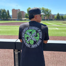 Person wearing a black t-shirt with a logo on a baseball field